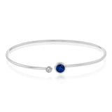 This understated white gold bangle features a subtle .08 ctw white diamond accent opposite a stunning .71 ctw sapphire. Perfect for stacking.