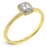 This exquisite, minimalist yellow gold ring features a halo containing .04 ctw of round white diamonds encircling a .16 ctw emerald cut white diamond