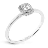 This exquisite, minimalist yellow gold ring features a halo containing .04 ctw of round white diamonds encircling a .16 ctw emerald cut white diamond