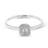 This exquisite, minimalist yellow gold ring features a halo containing .04 ctw of round white diamonds encircling a .16 ctw emerald cut white diamond