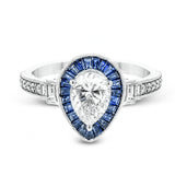 This beautiful pear-shaped setting displays .82 ctw of baguette sapphires in a halo around the center stone. The rest of the ring sparkles with .11 ctw of round diamonds and .17 ctw of baguette diamonds.