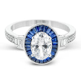 This remarkable ring features milgrain edging and .75 ctw of baguette shaped sapphires in its halo, flanked by .11 ctw of round white diamonds and .16 ctw of baguette shaped white diamonds.