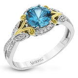 This two-toned vintage inspired right hand ring features a blue zircon center 3.11 ctw. surrounded by white diamonds 0.25 ctw and accented by natural yellow diamonds set in a yellow gold filigree detail.