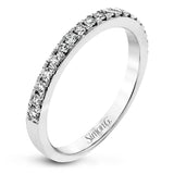 This white gold wedding set frames its centerpiece with .90 ctw of round white diamonds in a whimsical floral-inspired design.