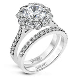 This white gold wedding set frames its centerpiece with .90 ctw of round white diamonds in a whimsical floral-inspired design.