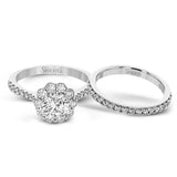 This white gold wedding set frames its centerpiece with .90 ctw of round white diamonds in a whimsical floral-inspired design.