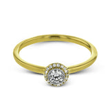 This exquisite, minimalist yellow gold ring features a halo containing .04 ctw of round white diamonds encircling a .16 ctw round white diamond centerpiece
