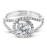 Crafted in the highest quality platinum, this engagement ring design features a two overlapping loops encircling the center stone set with .25 ctw of white diamonds.