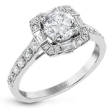 This sleek, contemporary white gold engagement ring contains .35 ctw of round white diamonds and .19 ctw of baguette shaped diamonds on its shank and unique, geometric halo