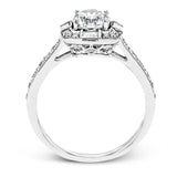 This sleek, contemporary white gold engagement ring contains .35 ctw of round white diamonds and .19 ctw of baguette shaped diamonds on its shank and unique, geometric halo