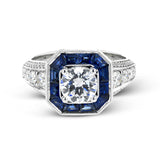 This stunning bridal ring design has a unique geometric halo set with 1.03 ctw of beautiful blue sapphires. The rest of the ring contains .52 ctw of white diamonds.