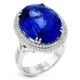 This right hand ring makes a statement with a stunning faceted Tanzanite center 20.44 ctw., held in place with double claw prongs, and has a double halo of white diamonds 1.05 cttw. The white gold setting has rose gold accents.