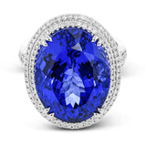 This right hand ring makes a statement with a stunning faceted Tanzanite center 20.44 ctw., held in place with double claw prongs, and has a double halo of white diamonds 1.05 cttw. The white gold setting has rose gold accents.
