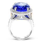 This right hand ring makes a statement with a stunning faceted Tanzanite center 20.44 ctw., held in place with double claw prongs, and has a double halo of white diamonds 1.05 cttw. The white gold setting has rose gold accents.