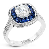 Specially shaped sapphires formed a halo around the center stone in this remarkable engagement ring, accented by .42 ctw of white diamonds as well.