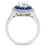 Specially shaped sapphires formed a halo around the center stone in this remarkable engagement ring, accented by .42 ctw of white diamonds as well.