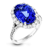 This dazzling vintage-inspired ring in white gold features a gorgeous 7.01 ctw tanzanite framed by 1.16 ctw of round white diamonds in a beautiful halo and split-shank design.