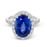This dazzling vintage-inspired ring in white gold features a gorgeous 7.01 ctw tanzanite framed by 1.16 ctw of round white diamonds in a beautiful halo and split-shank design.