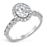This white gold ring's clean, modern design features a halo and shank that dazzle with .70 ctw of round white diamonds.