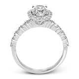 This white gold ring's clean, modern design features a halo and shank that dazzle with .70 ctw of round white diamonds.