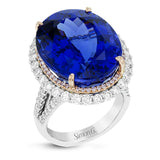 Opulent and glamorous, this white and rose gold ring features a jaw-dropping 28.60 ctw oval shaped tanzanite ringed by a double halo and a total of 1.80 ctw of round white diamond accents.