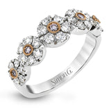 This whimsical white gold ring features .78 ctw of round white diamonds accentuated by .07 ctw of round pink diamonds as well as rose gold details in a playful floral design.
