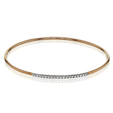 This lovely 18k rose gold bangle contains .13 ctw of white diamonds in a simple line. This bangle is perfect for stacking, or making a delicate statement all on its own.