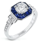 This 18k white gold engagement setting would be a perfect 'something blue' with .79 ctw of baguette sapphires in a halo surrounding the center stone. These are framed by .33 ctw of princess cut diamonds and .11 ctw of round brilliant diamonds.