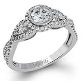 This 18k white gold wedding set has a distinctive design with a milgrain accented bezel center stone setting, .15 ctw pear side stones, and .50 ctw of round brilliant diamonds.