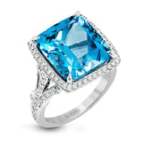 A bright blue 9.57 ct aquamarine is the central focus of this classic halo 18k white gold ring set with .68 ctw of white diamonds.