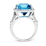 A bright blue 9.57 ct aquamarine is the central focus of this classic halo 18k white gold ring set with .68 ctw of white diamonds.