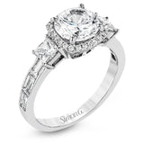 The impressive circular halo of this white gold engagement ring is set with .10 ctw round cut white diamonds and emphasized by .43 ctw princess cut diamonds and .58 baguette cut diamonds.