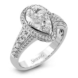 This remarkable 18k white gold ring contains a 1.28 ctw two-piece mosaic center which creates the look of a pear shaped diamond. This centerpiece is accented .48 ctw of white round brilliant diamonds.