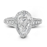 This remarkable 18k white gold ring contains a 1.28 ctw two-piece mosaic center which creates the look of a pear shaped diamond. This centerpiece is accented .48 ctw of white round brilliant diamonds.