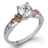 This delicate white gold ring features lovely rose gold accents on the shank and is set with .24 ctw of round cut white diamond accents.