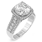 This eye-catching modern white gold ring is accentuated by an elegant halo highlighted with .64 ctw of round cut white diamonds.
