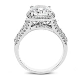 This eye-catching modern white gold ring is accentuated by an elegant halo highlighted with .64 ctw of round cut white diamonds.