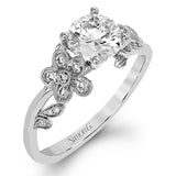 Featuring delicate floral designs on the shank, this modern white gold ring is complemented by .19 ctw of round cut white diamonds and .02 ctw pink diamond accents.