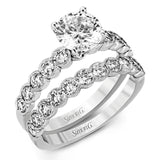This engagement and wedding band set combines old and new with 1.09 ctw of round brilliant diamonds bezel set into 18k white gold, accented with vintage-inspired milgrain.