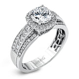 Featuring an impressive halo, this contemporary white gold engagement ring is accented by .22 ctw of round cut white diamonds and .42 ctw princess cut diamonds.