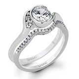 This distinctive, swirling ring design is set with .19 ctw and holds the center stone in a partial bezel setting.