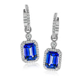 These elegant 18k white gold drop earrings contain 3.43 ctw of tanzanite stones which are accented by .45 ctw of white diamonds.