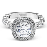 The delicate design of this classic white gold engagement ring features a sparkling pave halo accented with .86 ctw of shimmering round cut white diamonds.