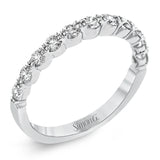 The delicate design of this classic white gold engagement ring features a sparkling pave halo accented with .86 ctw of shimmering round cut white diamonds.