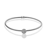 This dazzling modern white gold bangle bracelet is accentuated by an open design and highlighted with a lovely oval setting complemented with .15 ctw round cut white diamonds.