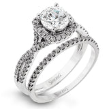 Presenting a lovely twisted shank design, this contemporary white gold engagement ring and wedding band set is accentuated with .44 ctw round cut white diamonds.