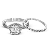 Presenting a lovely twisted shank design, this contemporary white gold engagement ring and wedding band set is accentuated with .44 ctw round cut white diamonds.