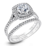 This eye-catching contemporary white gold engagement ring and wedding band set features an impressive halo accented by .63 ctw round cut white diamonds.
