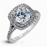 This remarkable white gold engagement ring and wedding band set features a contemporary setting with an eye-catching halo highlighted by .67 ctw of round cut white diamonds.