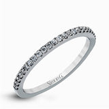 This remarkable white gold engagement ring and wedding band set features a contemporary setting with an eye-catching halo highlighted by .67 ctw of round cut white diamonds.